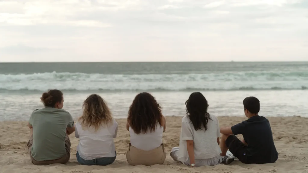 Photographie représentant 5 jeunes sur une plage qui regardent l'horizon. Photo reproduite avec l’aimable autorisation d’Arte France et SEPPIA pour le projet Justice climatique, une série de Zouhair Chebbale en collaboration avec Léa Ducré