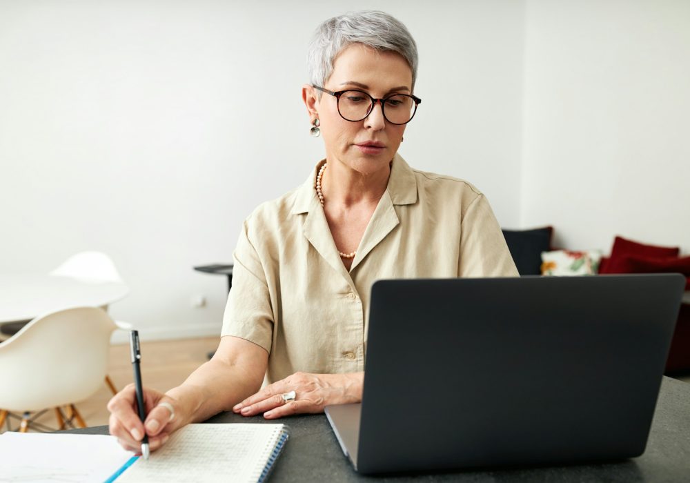 Photo qui représente une femme qui consulte son ordinateur.