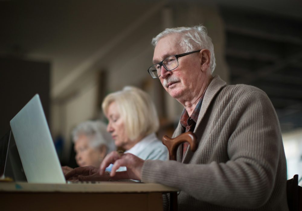 Photo qui représente un homme utilisant son ordinateur.