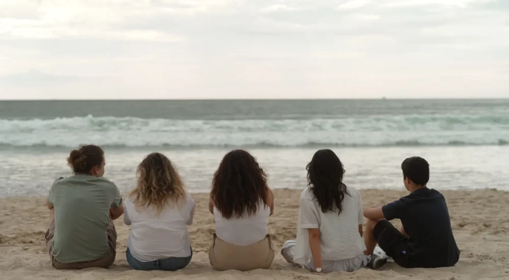 Photographie représentant 5 jeunes sur une plage qui regardent l'horizon. Photo reproduite avec l’aimable autorisation d’Arte France et SEPPIA pour le projet Justice climatique, une série de Zouhair Chebbale en collaboration avec Léa Ducré